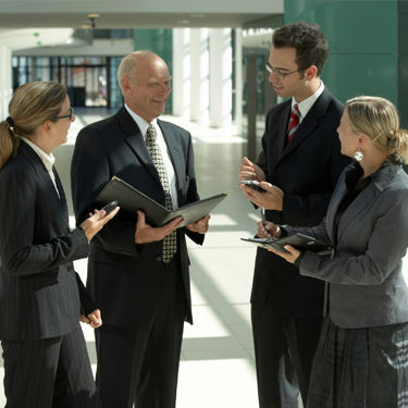 A group of four businesspeople discussing notes